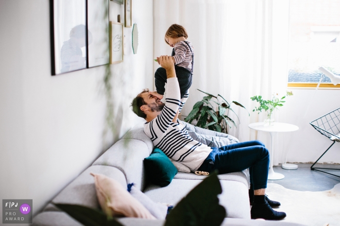 Photo by: <a href="https://www.fpja.com/documentary-family-photography-contests/jolanda-boer/zuid-holland/2081071">Jolanda Boer - Netherlands</a> A little boy puts his foot on his father's face when he lifts him in the air in this photograph created by a Netherlands family photojournalist.