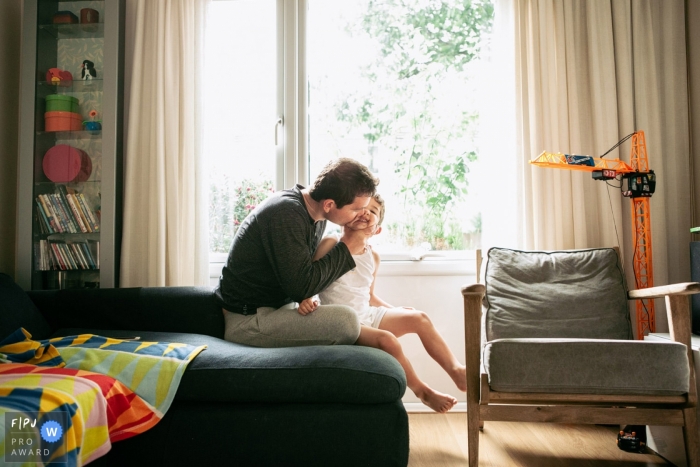 A father kisses his son on the cheek in this photo by a Surrey, England family photographer