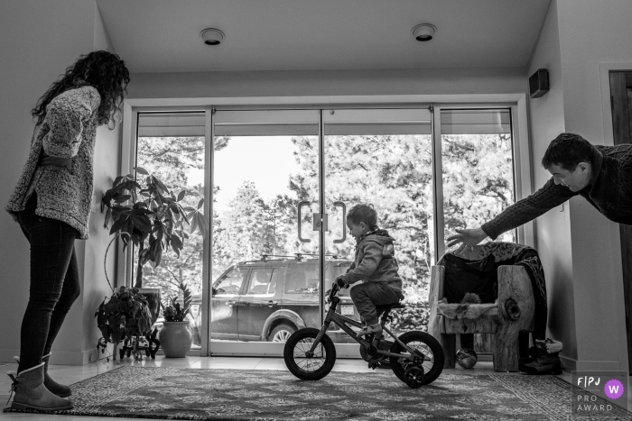 Un père et une mère enseignent à leur fils comment faire du vélo sur cette photo enregistrée par un photographe de famille de style documentaire primé dans le comté de Boulder.