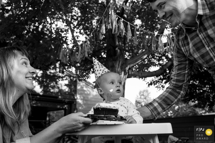 Photo by: <a href="https://www.fpja.com/documentary-family-photography-contests/casie-zalud/boulder/2082846">Casie Zalud - United States</a> Boulder family photojournalist captured this picture of mom and dad excited to present their child with a smash cake for her first birthday