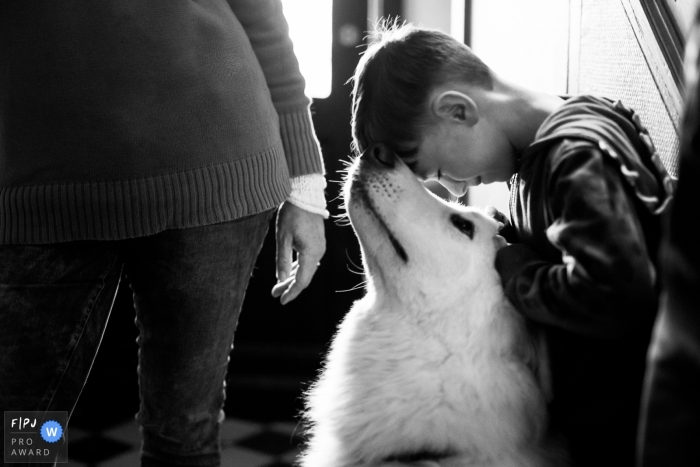 A little boy touches his forehead to his dog's nose in this photograph created by a Brussels family photojournalist. 