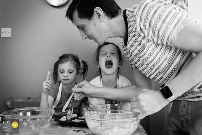 Photo by: <a href="https://www.fpja.com/documentary-family-photography-contests/alice-chapman/cambridgeshire/2083391">Alice Chapman - United Kingdom</a> Cambridgeshire photo family journalist captured this black and white image of a father and his two children making cupcakes together