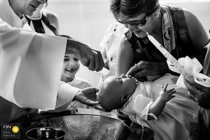 Le photojournaliste de la famille Minas Gerais a capturé cette photo en noir et blanc d'un bébé baptisé alors qu'il était entouré de famille