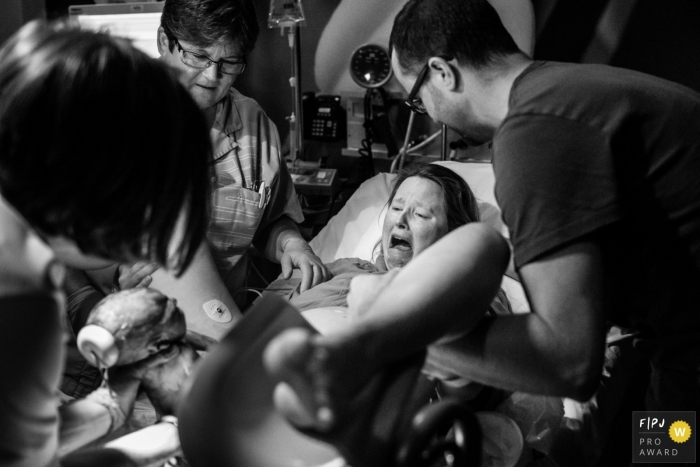 Photo by: <a href="https://www.fpja.com/documentary-family-photography-contests/jacqueline-dersjant/amsterdam/2083906">Jacqueline Dersjant - Netherlands</a> Noord Holland hospital photographer captured this emotional black and white photo of the mothers expression as she sees her baby for the first time just after birth