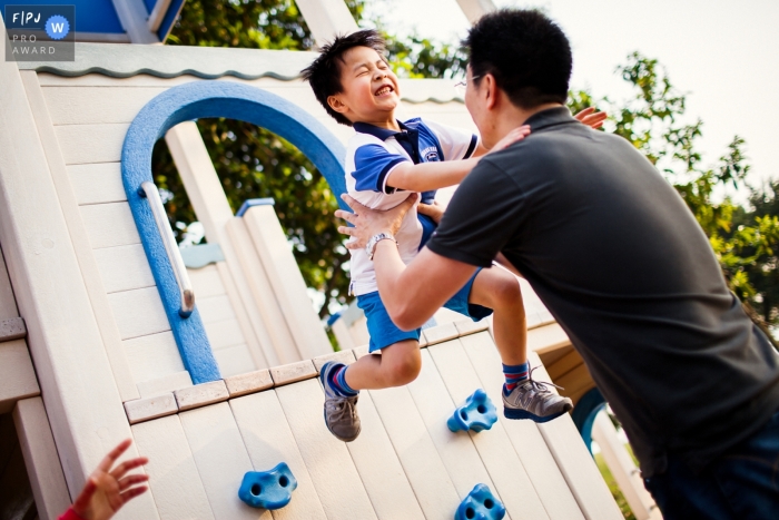 Photo by: <a href="https://www.fpja.com/documentary-family-photography-contests/chris-shum/san-francisco/2084006">Chris Shum - United States</a> A boy jumps down from a play set into his father's arms in this photograph by a San Francisco, CA documentary family photographer.