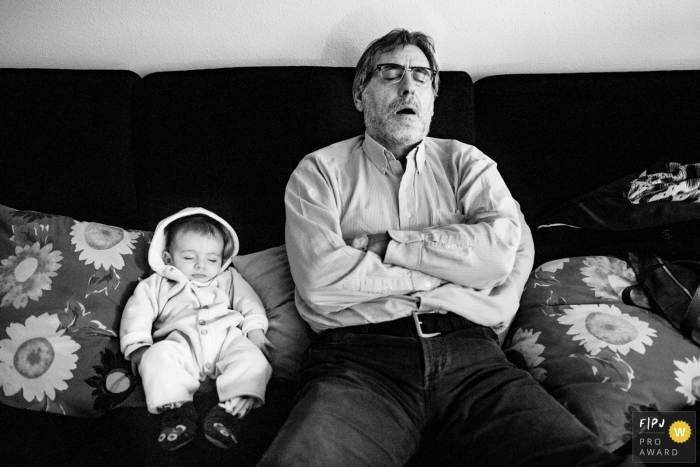 Valencia family photojournalist created this black and white image of an infant and grandfather sleeping peacefully on a couch 