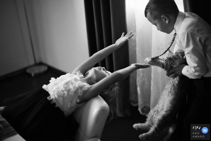 Photo by: <a href="https://www.fpja.com/documentary-family-photography-contests/elena-petrova/saint-petersburg/2084866">Elena Petrova - Russia</a> A little girl and a cat both reach for a little boy's tie in this documentary-style family image recorded by a Saint Petersburg, Russia photographer.