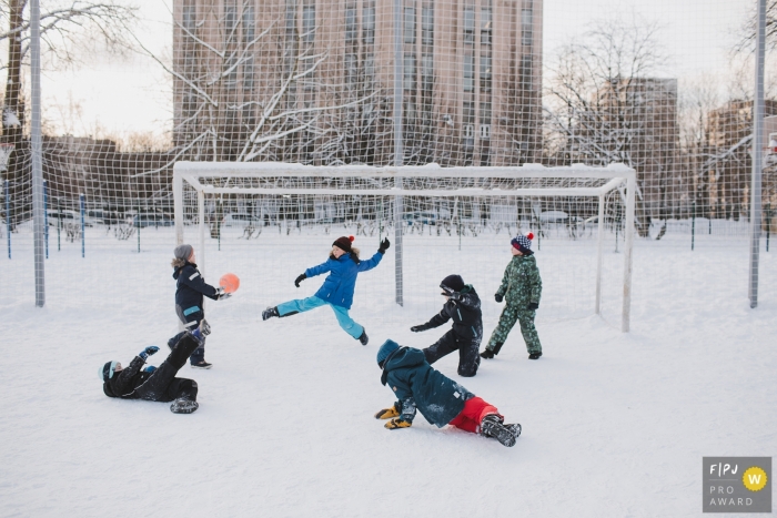 Photo by: <a href="https://www.fpja.com/documentary-family-photography-contests/elena-petrova/saint-petersburg/2084901">Elena Petrova - Russia</a> Saint-Petersburg family photojournalist captured this photo of kids playing soccer in a snow covered park