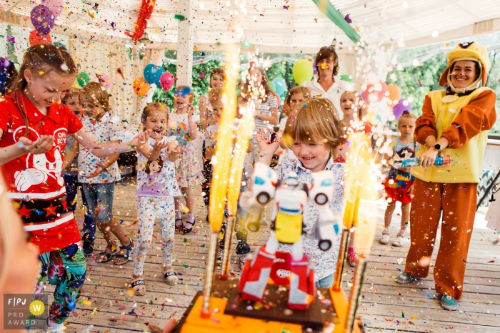 Ce portrait d'un jeune garçon devant son gâteau d'anniversaire de robot entouré de famille et d'amis jetant des confettis a été capturé par un photojournaliste de la famille de Saint-Pétersbourg