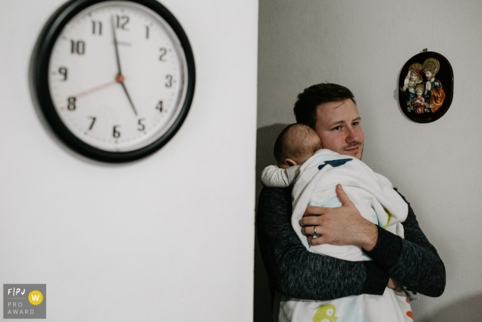 This photo of a father holding his sleeping infant was captured by a Florianopolis family photojournalist