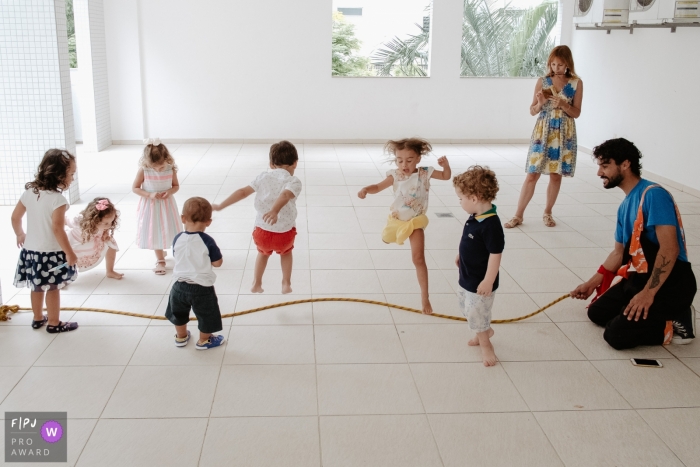 Plusieurs enfants jouent avec une corde à sauter dans cette photo de famille réalisée par un photographe de Santa Catarina.