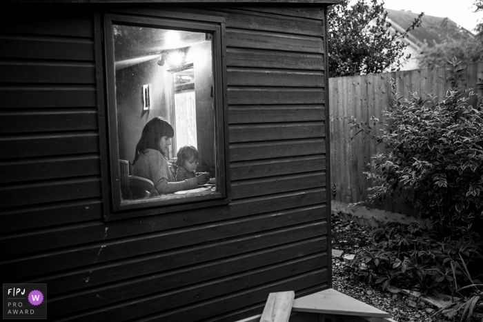 Photo by: <a href="https://www.fpja.com/documentary-family-photography-contests/raluca-chase/essex/2085306">Raluca Chase - United Kingdom</a> A mother and her little girl write together inside their house in this photograph by an Essex, England documentary family photographer.