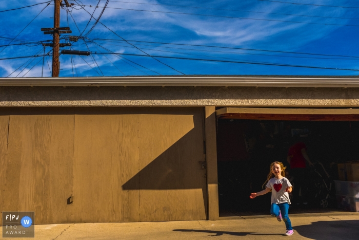 Une petite fille sort du garage sur cette photo primée d'un photographe de famille de Los Angeles, en Californie.