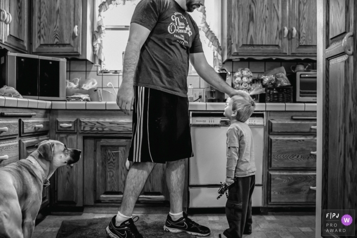 Photo by: <a href="https://www.fpja.com/documentary-family-photography-contests/annie-bang/los-angeles/2085471">Annie Bang - United States</a> A father pats his son's head as the family dog watches in this photo recorded by a Los Angeles, CA award-winning, documentary-style family photographer.
