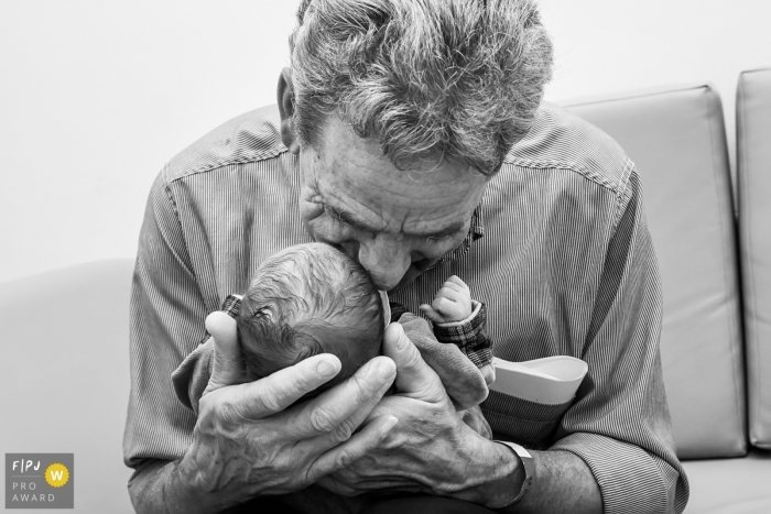 Photo by: <a href="https://www.fpja.com/documentary-family-photography-contests/gisele-soares/rio-de-janeiro/2085796">Gisele Soares - Brazil</a> Rio Grande do Sul hospital photojournalist captured this black and white photo of a grandfather meeting a newborn for the first time