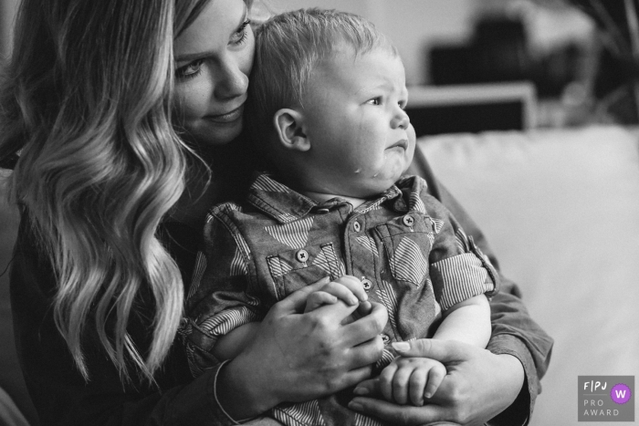 Photo by: <a href="https://www.fpja.com/documentary-family-photography-contests/ron-storer/seattle/2086036">Ron Storer - United States</a> A mother holds and comforts her tearful baby boy in this photograph created by a Seattle, WA family photojournalist.