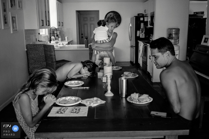 Children pray with their parents before their meal in this FPJA award-winning picture by a Key West, FL family photographer.