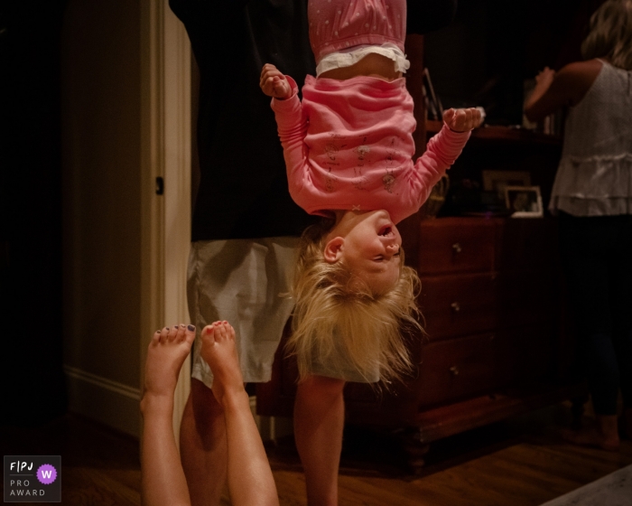 Photo by: <a href="https://www.fpja.com/documentary-family-photography-contests/julie-ambos/key-west/2086136">Julie Ambos - United States</a> A father holds his daughter upside down as she laughs in this photograph by a Key West, FL documentary family photographer.