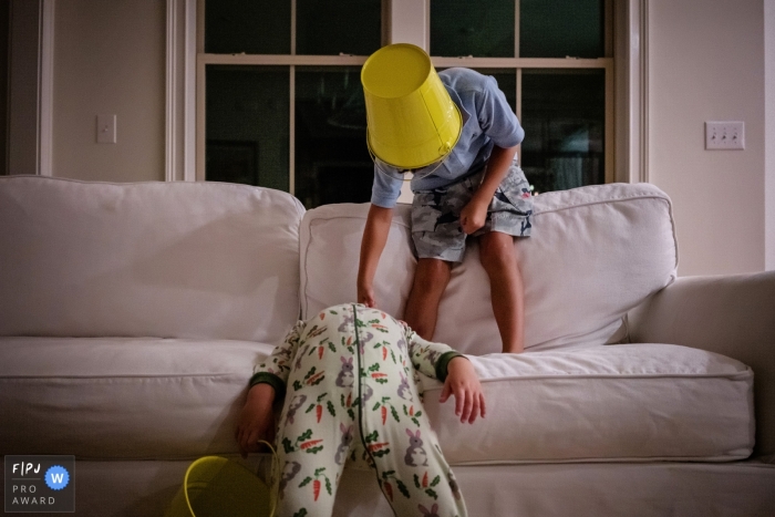 Deux jeunes garçons jouent avec des seaux jaunes sur un canapé dans cette image primée de la FPJA, capturée par un photographe de la famille Key West, en Floride.