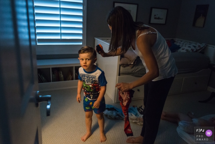  A mother attempts to brush her son's hair in this photo by a Los Angeles, CA award-winning family photographer. 