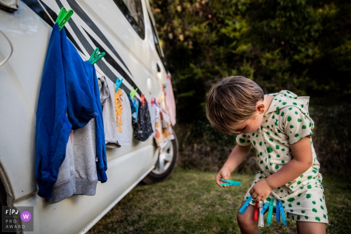 Photo by: <a href="https://www.fpja.com/documentary-family-photography-contests/kim-de-graeve/east-flanders/2086881">Kim De Graeve - Belgium</a> This photographer of a boy taking clothespins off the line and pinning them to his clothes was captured by a Flanders documentary family photographer