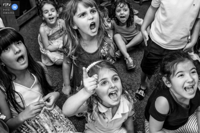 Photographe de famille brésilien, ce photographe de famille a capturé cette photo en noir et blanc d'un groupe d'enfants applaudissant avec passion