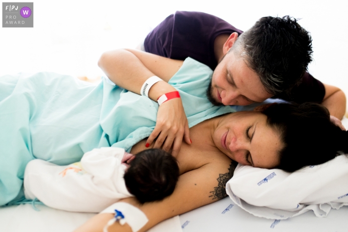 Photo by: <a href="https://www.fpja.com/documentary-family-photography-contests/morgana-secco/london/2087436">Morgana Secco - United Kingdom</a> London documentary family photographer captured this photo of a mother nursing her new baby as the father watches from close by