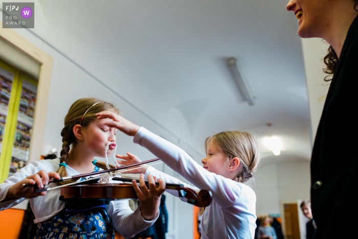 Slovenia documentary family photographer captured this funny photo of a girl practicing her violin while wearing a spaghetti mustache