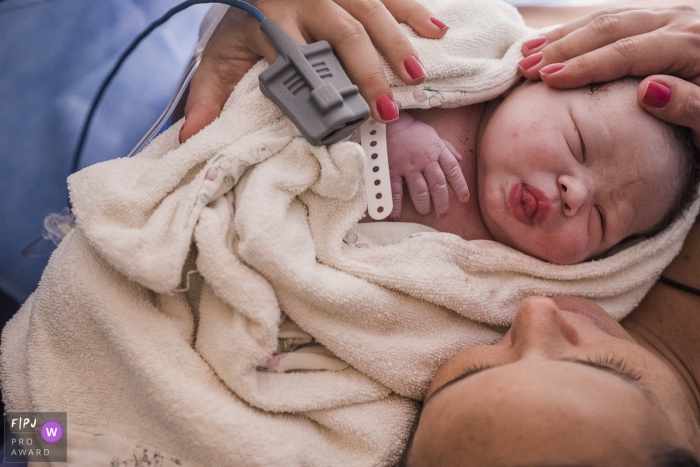 Photo by: <a href="https://www.fpja.com/documentary-family-photography-contests/clara-sampaio/rio-de-janeiro/2089131">Clara Sampaio - Brazil</a> A newborn dozes peacefully on the mothers chest in this photo captured by a Brazil documentary family photographer