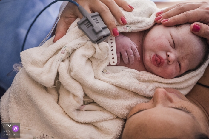 A newborn dozes peacefully on the mothers chest in this photo captured by a Brazil documentary family photographer