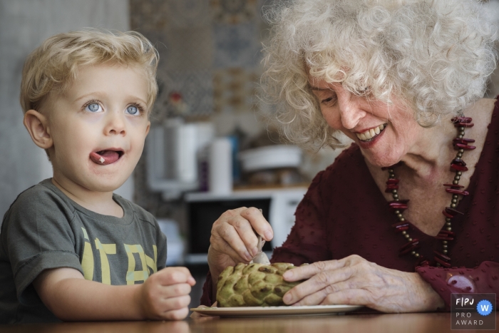 Un photographe de famille documentaire brésilien a capturé cette photo d'un petit garçon aux cheveux blonds se léchant les lèvres après avoir partagé une collation avec sa grand-mère