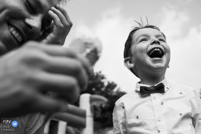 Photo by: <a href="https://www.fpja.com/documentary-family-photography-contests/joshua-dhondt/antwerpen/2089486">Joshua Dhondt - Belgium</a> A little boy stands outside laughing in this award-winning photo by an Antwerpen family photographer.