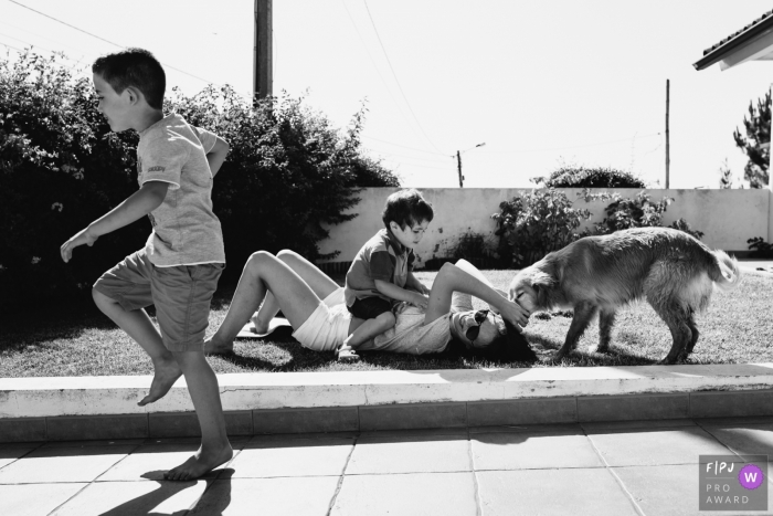 Two brothers play with their mom and dog outside in this picture captured by an Aveiro, Portugal family photojournalist. 