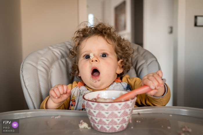 Une petite fille a l’air surprise d’avoir accidentellement l’alimentation sur le nez dans cette photo de famille prise par un photographe nantais.