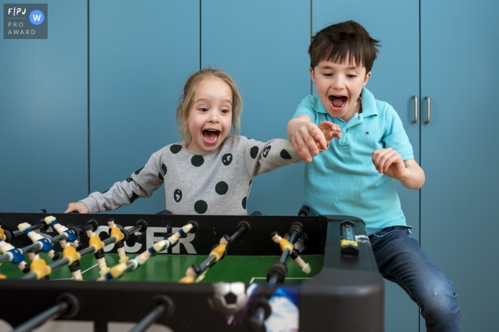 Photo by: <a href="https://www.fpja.com/documentary-family-photography-contests/gonda-meurs/noord-holland/2091616">Gonda Meurs - Netherlands</a> A brother and sister play foosball together excitedly in this picture captured by a Netherlands family photojournalist.
