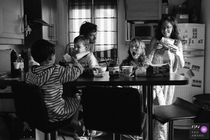 A family eats breakfast together sleepily in the morning in this photograph created by a Paris, France family photojournalist. 