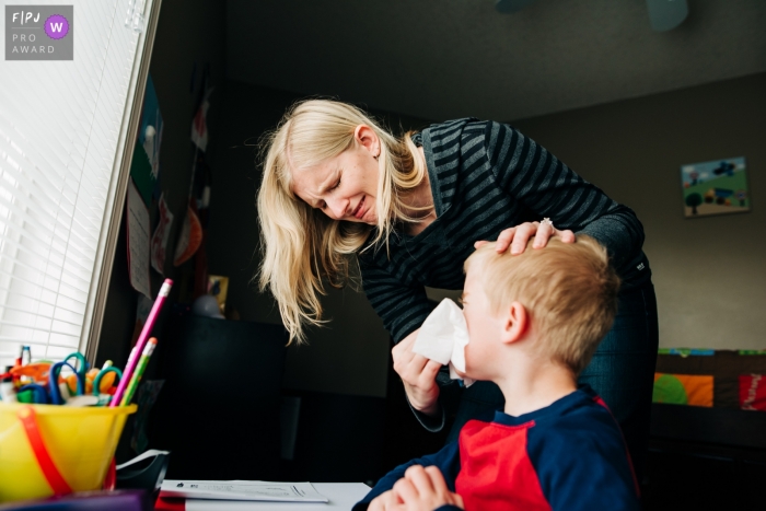 Une mère fait la grimace en essuyant le nez de son fils sur cette image créée par un photographe de la famille Boulder, CO.