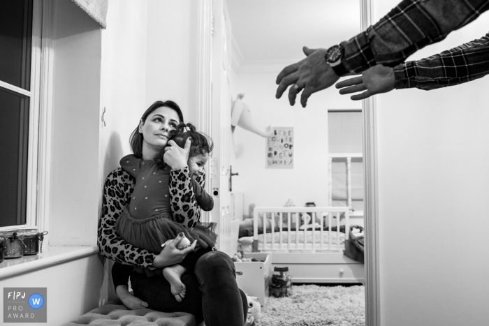 Photo by: <a href="https://www.fpja.com/documentary-family-photography-contests/raluca-chase/essex/2093246">Raluca Chase - United Kingdom</a> A father reaches for his daughter while her mother holds her in this photograph by an Essex, England documentary family photographer.
