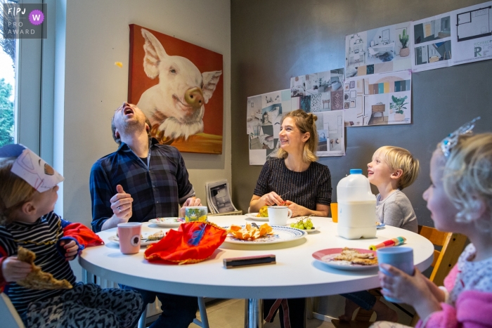 Photo by: <a href="https://www.fpja.com/documentary-family-photography-contests/angeline-dobber-jansen/gelderland/2093506">Angeline Dobber-Jansen - Netherlands</a> Children watch as their father tosses a chip in the air to catch in his mouth in this photo by a Gelderland, Netherlands award-winning family photographer.