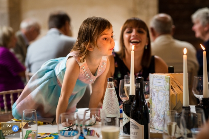 Photo by: <a href="https://www.fpja.com/documentary-family-photography-contests/catherine-hill/kent/2095156">Catherine Hill - United Kingdom</a> A little girl leans across a table and tries to blow out the candle in this Family Photojournalist Association contest awarded photo created by a Kent, England family photographer.