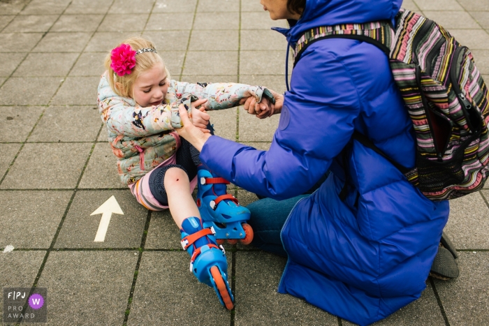 Photo by: <a href="https://www.fpja.com/documentary-family-photography-contests/liesbeth-parlevliet/zuid-holland/2095326">Liesbeth Parlevliet - Netherlands</a> A mother tries to help her daughter up after she falls while rollerblading in this photograph by a Netherlands documentary family photographer.