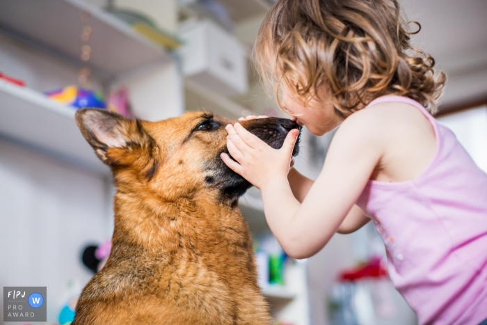 Photo by: <a href="https://www.fpja.com/documentary-family-photography-contests/florent-fauqueux/la-rochelle/2095776">Florent Fauqueux - France</a> A little girl kisses a dog on the nose in this photo recorded by a La Rochelle award-winning, documentary-style family photographer.