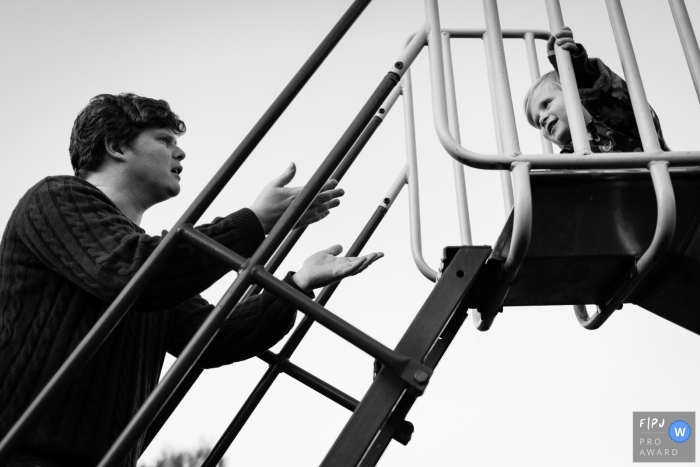 Photo by: <a href="https://www.fpja.com/documentary-family-photography-contests/alice-chapman/cambridgeshire/2095991">Alice Chapman - United Kingdom</a> A father tries to help his son down from a slide in this Family Photojournalist Association contest awarded photo created by a Cambridgeshire, England family photographer.