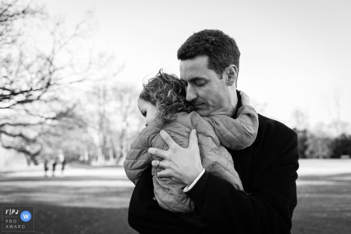 A father holds his little girl tightly in the cold weather in this FPJA award-winning picture by a Cambridgeshire, England family photographer.