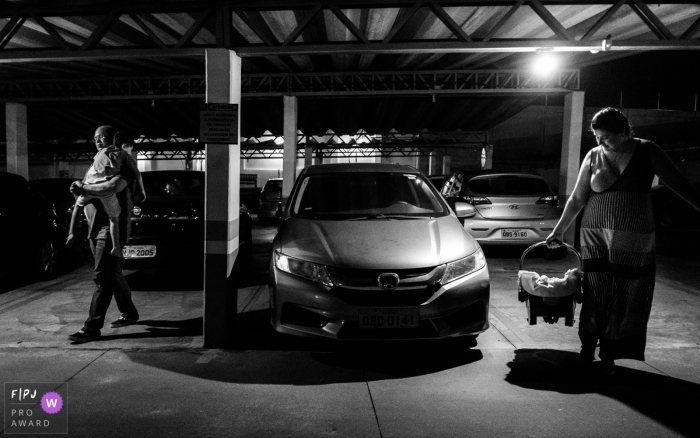Photo by: <a href="https://www.fpja.com/documentary-family-photography-contests/lisandro-castro/cuiab%C3%A1/2096396">Lisandro Castro - Brazil</a> A mother and father carry their two children as they exit their car in this picture captured by a Cuiaba family photojournalist.