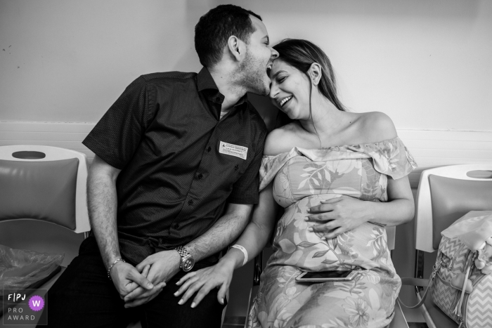 Photo by: <a href="https://www.fpja.com/documentary-family-photography-contests/gabi-marques/minas-gerais/2097221">Gabi Marques - Brazil</a> A pregnant woman sits next to her husband as he jokingly bites her forehead in this family picture by a Minas Gerais, Brazil photographer.