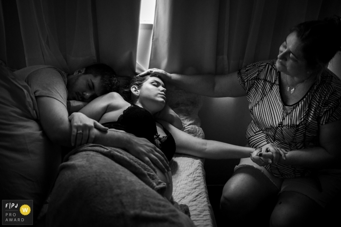 This black and white photo of a laboring mother captured during a home birth was composed by a Brazil documentary family photographer