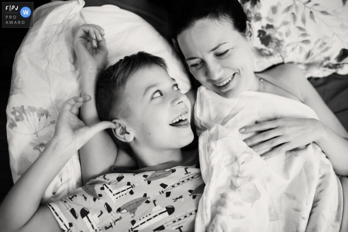 Photo by: <a href="https://www.fpja.com/documentary-family-photography-contests/elena-petrova/saint-petersburg/2097426">Elena Petrova - Russia</a> Saint-Petersburg documentary family photographer captured this black and white photo of a mother and child laying on a couch together
