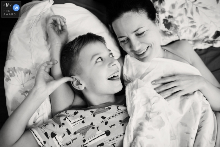 Photographe de famille documentaire de Saint-Pétersbourg, photo en noir et blanc d'une mère et d'un enfant allongés sur un canapé