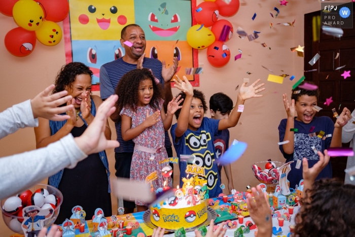 Children celebrate around a birthday cake in this image created by a Rio de Janeiro, Brazil family photographer.